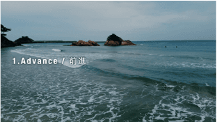 海岸の空撮シーン。Advance shot（前進）を示す講座用スライド