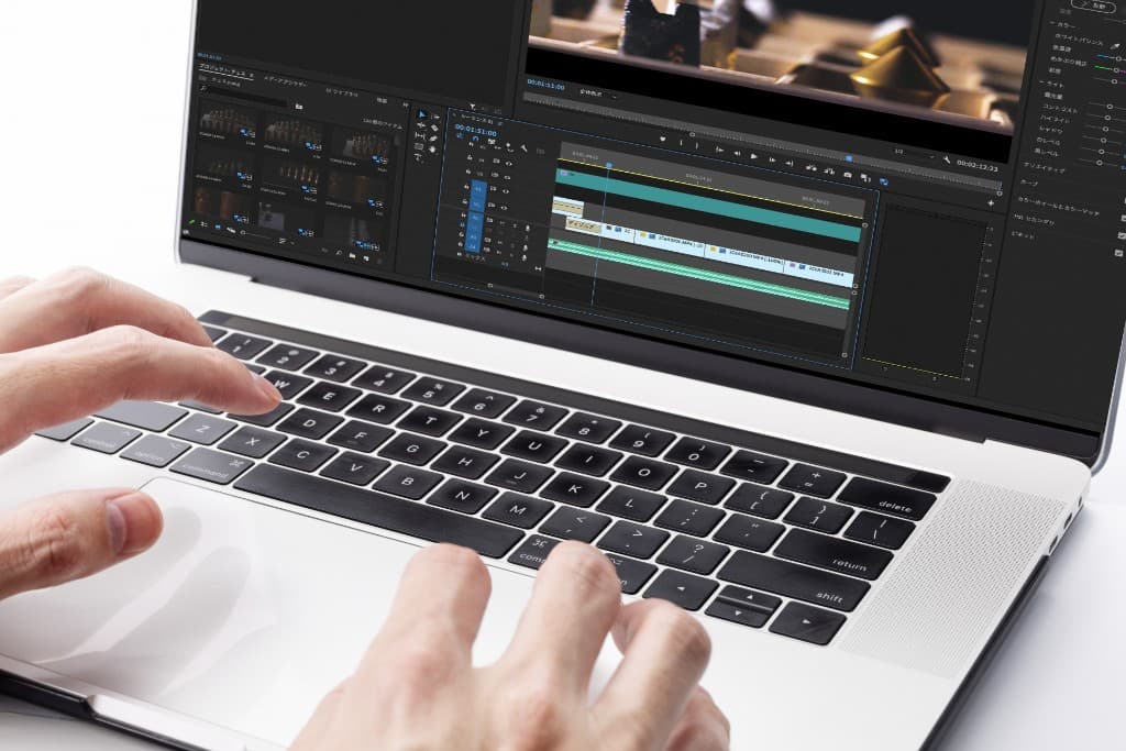 ノートパソコンで動画編集ソフトを操作し、映像制作を行っている様子